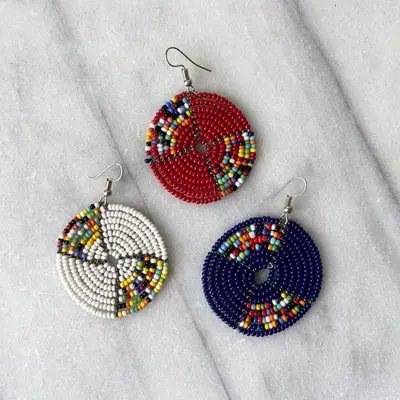 threeadedadedadedadedaded earrings with multicolored accents on a table at Mabegi african Designs in Arusha