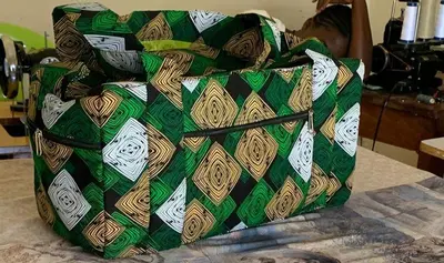 a green and brown bag sitting on top of a bed at Mabegi african Designs in Arusha