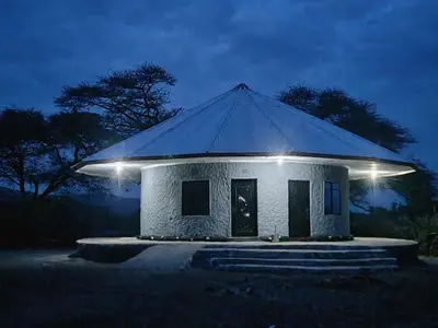 a small house with a pyramid roof at night at Lengai Maasai homestay in Mtowabaga