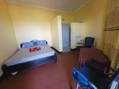 a room with a bed and a chair in it at Lengai Maasai homestay in Mtowabaga
