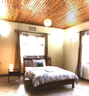 a bedroom with a bed with a wooden ceiling at Kibebe ataraxia house in Arusha