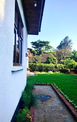 a porch of a house with a green yard at Kibebe ataraxia house in Arusha