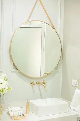 a bathroom with a round mirror above a sink at French Unit - 1st floor sleeps 2 in Arusha