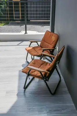a brown chair sitting next to a wall at French Unit - 1st floor sleeps 2 in Arusha