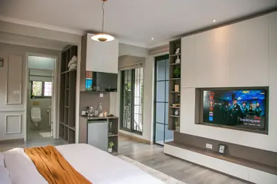 a bedroom with a bed and a tv on a wall at French Unit - 1st floor sleeps 2 in Arusha