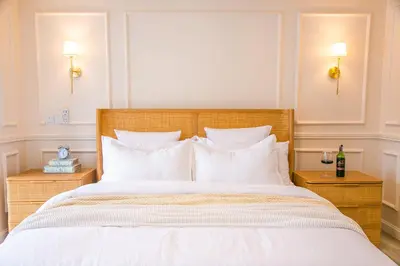 a bedroom with a large bed with white sheets and pillows at Rabi Residence - Two French units sleeps 4 in Arusha