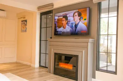 a living room with a fireplace with a tv above it at Rabi Residence - Two French units sleeps 4 in Arusha