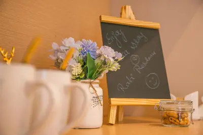 a table with a vase of flowers and a chalkboard at Rabi Residence - Two French units sleeps 4 in Arusha