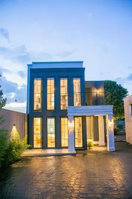 a large blue house with a lot of windows at Rabi Residence - Two French units sleeps 4 in Arusha