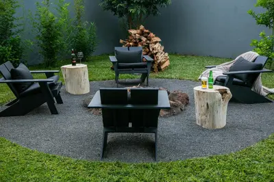 a patio with chairs and tables and logs at Rabi Residence - Two French units sleeps 4 in Arusha