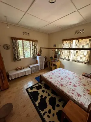 a bedroom with a cow patterned bed and a table at Kwetu Homestay Spacious 4BR Home in Moshi