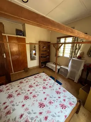 a bedroom with a large bed with a flowered blanket at Kwetu Homestay Spacious 4BR Home in Moshi
