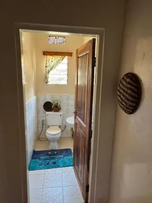 a bathroom with a toilet and a window at Kwetu Homestay Spacious 4BR Home in Moshi