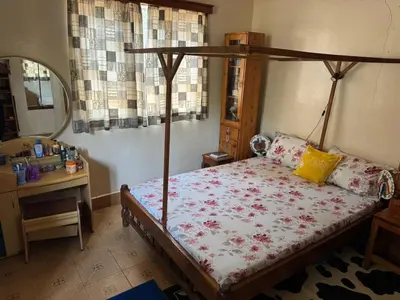 a bedroom with a bed and a desk and a mirror at Kwetu Homestay Spacious 4BR Home in Moshi