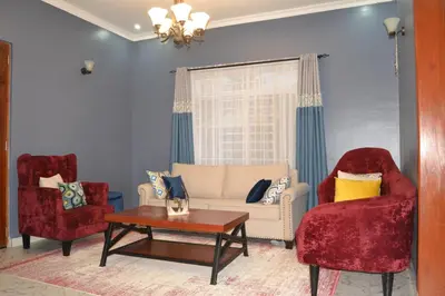 a living room with two chairs and a couch at Molly's Cozy Place in Arusha