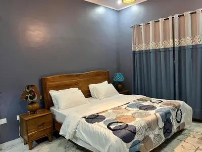 a bedroom with a bed and a blue wall at Molly's Cozy Place in Arusha