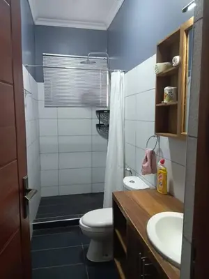 a bathroom with a toilet and a sink and a shower at Molly's Cozy Place in Arusha