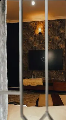 a view of a bedroom with a tv on a wall at Cozy-Homey with solar system -Firepit- Free Parking-Gardenswing in Arusha
