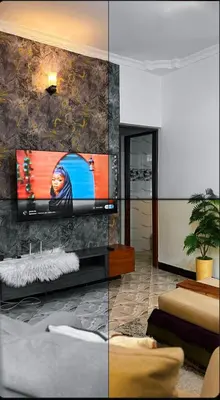 a living room with a flat screen tv on a wall at Cozy-Homey with solar system -Firepit- Free Parking-Gardenswing in Arusha