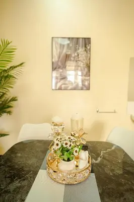 a table with a tray with candles and flowers on it at Cozy Urban home in Arusha