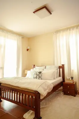 a bedroom with a large bed with white pillows at Cozy Urban home in Arusha