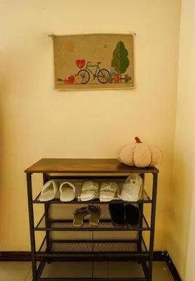 a shelf with shoes and a picture of a bike at Cozy Urban home in Arusha