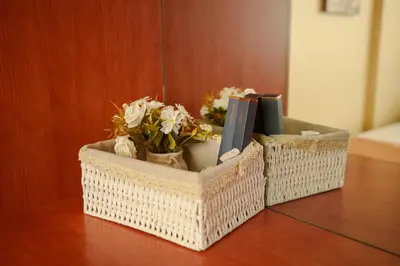 two baskets on a table with flowers and books at Cozy Urban home in Arusha