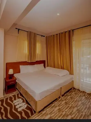 a bedroom with a large bed and a night stand at River point inn in Arusha