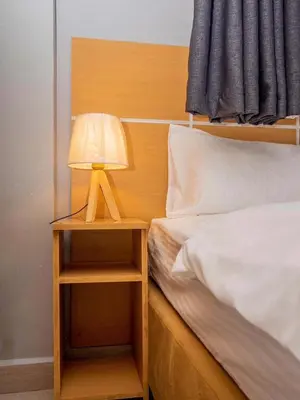 a lamp on a night stand next to a bed at River point inn in Arusha