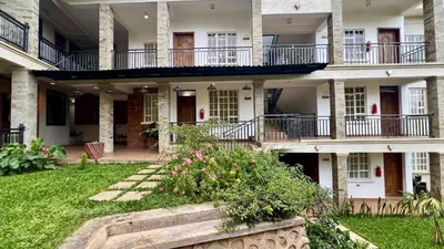 a building with balconies and a yard with flowers at Iwandaa Apartments in Nkoanrua