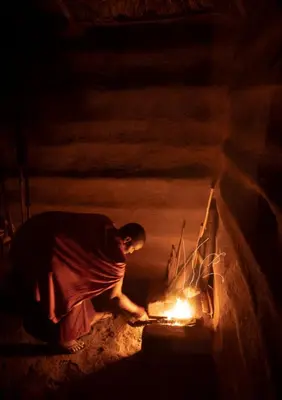 a man standing next to a fire in an oven at Ewang'ani Maasai Cultural Village - Overnight Experience and Tour in Sanya Chini Station