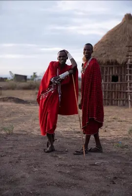 two people are standing in front of a hut at Ewang'ani Maasai Cultural Village - Overnight Experience and Tour in Sanya Chini Station