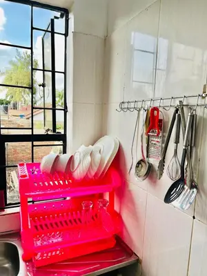 a red dish drying rack in a kitchen with utensils at Oshey Home Stay in Arusha