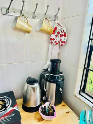 a kitchen counter with a coffee maker and utensils at Oshey Home Stay in Arusha