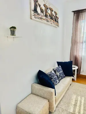 a living room with a couch and a chair at Oshey Home Stay in Arusha