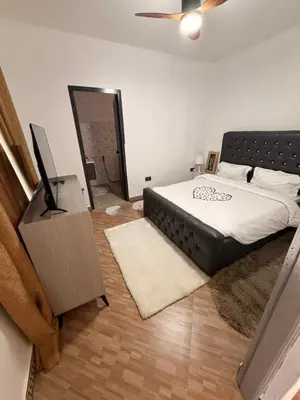 a bedroom with a bed and a flat screen tv at Afrika Royal Safari in Arusha