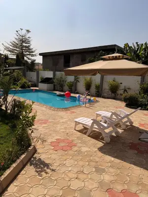 a swimming pool with two chairs and an umbrella at Afrika Royal Safari in Arusha
