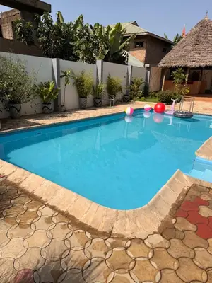 a large swimming pool with blue water in a yard at Afrika Royal Safari in Arusha
