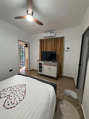 a bedroom with a bed and a flat screen tv at Royal Safary Appartement in Arusha