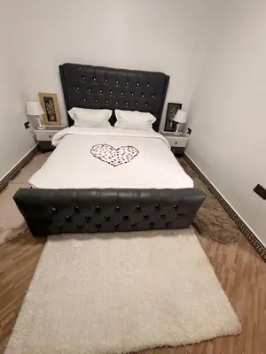 a bedroom with a large bed with a black headboard at Royal Safary Appartement in Arusha