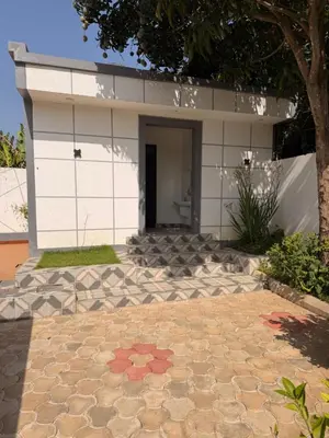 a house with a stone patio in front of it at Royal Safary Appartement in Arusha