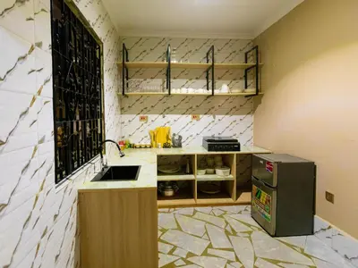 a kitchen with a sink and a counter with a refrigerator at Msafiri Haven in Moshi