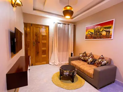 a living room with a couch and a tv at Msafiri Haven in Moshi