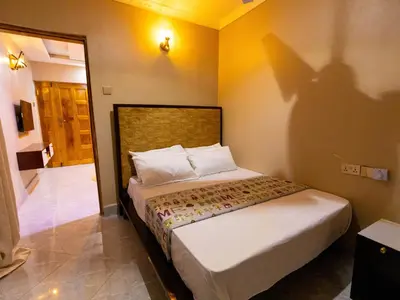 a bedroom with a bed with a shadow on the wall at Msafiri Haven in Moshi