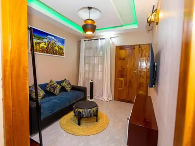 a living room with a blue couch and a table at Msafiri Haven in Moshi