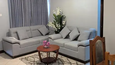 a living room with a couch and a table at AvocadoAirbnb in Arusha
