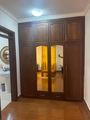 a room with wooden cabinets and a bathroom with a sink at Royal Afrika Safari in Arusha