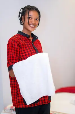 a woman in a red shirt holding a white pillow at Kilimont Hotel