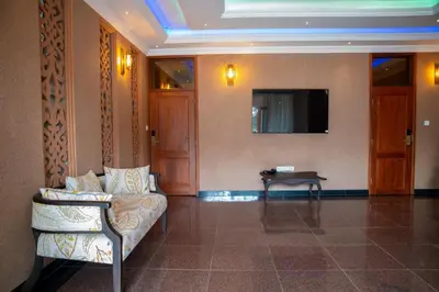 a living room with a couch and a tv on a wall at Kilimont Hotel
