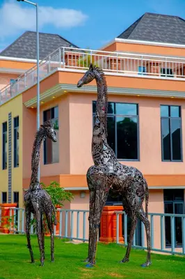 a statue of two giraffes in front of a building at Kilimont Hotel